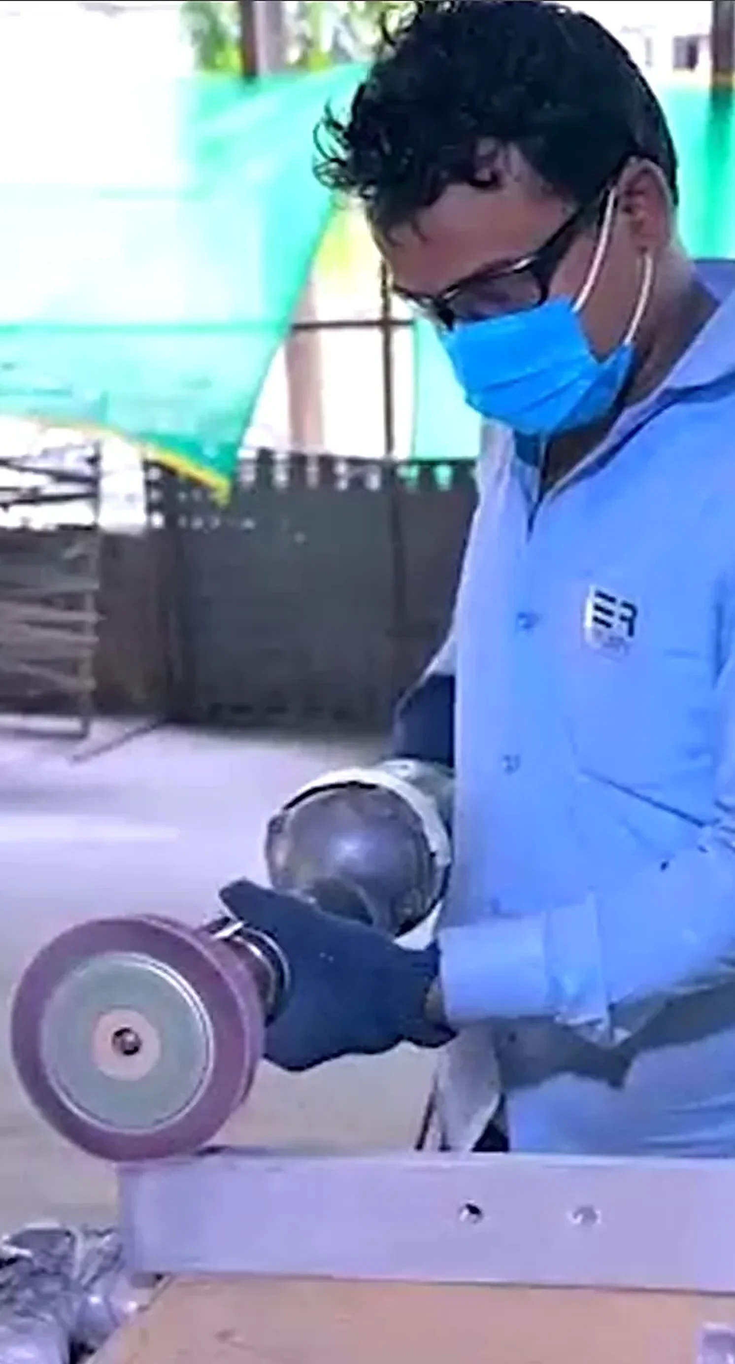Fabricator grinding a metal component in the workshop